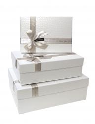 Набор из трёх прямоугольных блестящих белых подарочных коробок с бантом из ленты, отделка фактурной бумагой, размер 33*24*11,5 см.