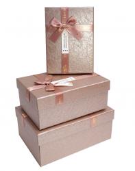 Набор из трёх прямоугольных подарочных коробок пудрово-розового цвета, отделка фактурной матово-перламутровой бумагой, бант из ленты, размер 22*16*9,5 см.