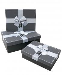 Набор из трёх прямоугольных подарочных коробок серого цвета с бантом из ленты, отделка софт-тач бумагой, размер 29*21*9,5 см.