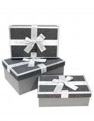 Набор из трёх графитовых прямоугольных подарочных коробок с золотистыми краями и бантом из ленты, отделка фактурной блестящей бумагой, размер 22*16*9,5 см.